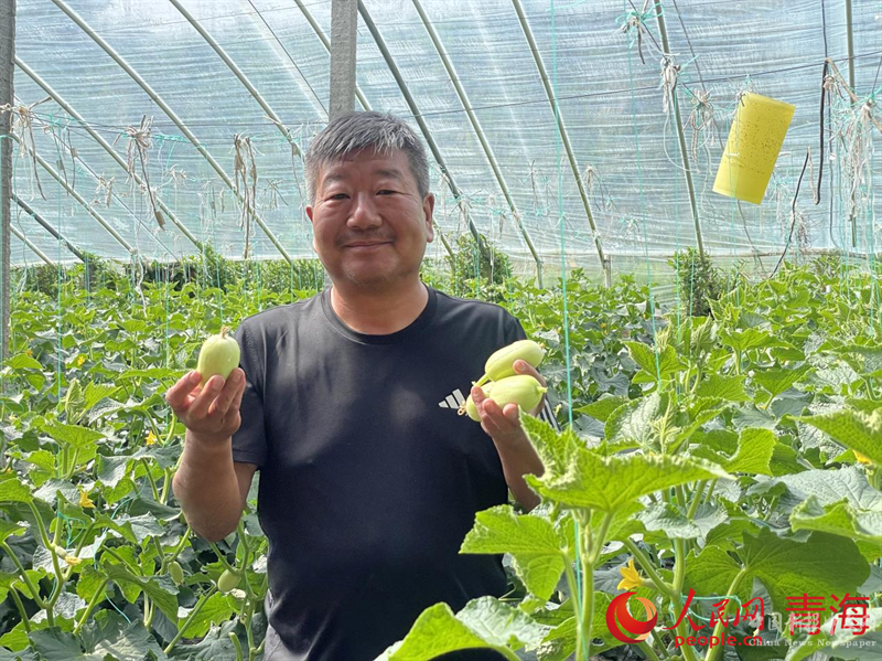 李希志展示新鮮采摘的水果。人民網(wǎng) 況玉攝